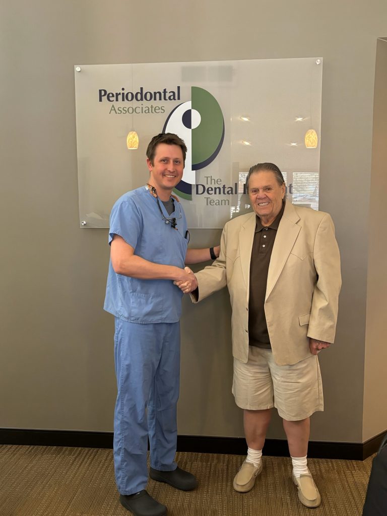 Man in scrubs shaking hands with man in a suit